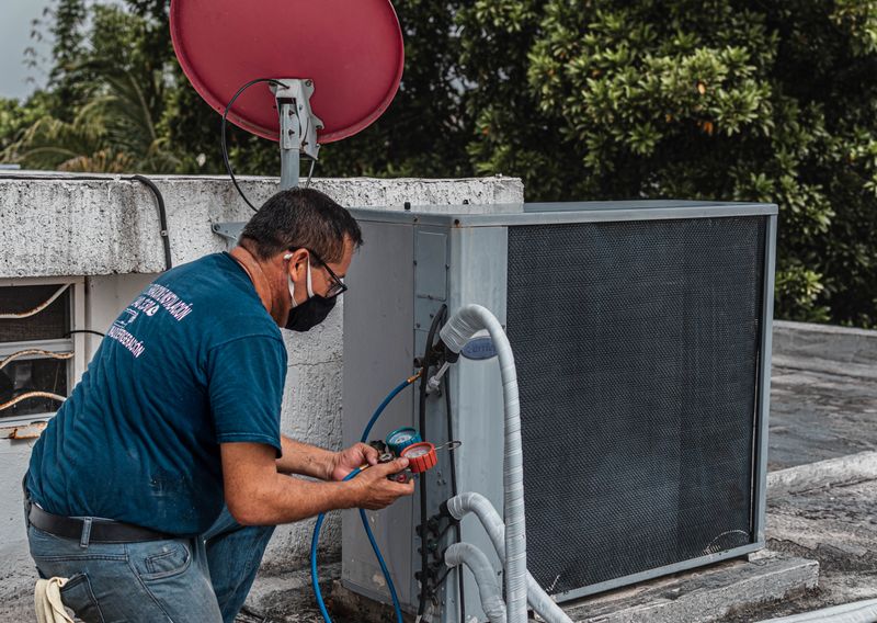 Air conditioning technician repairing outdoor HVAC unit